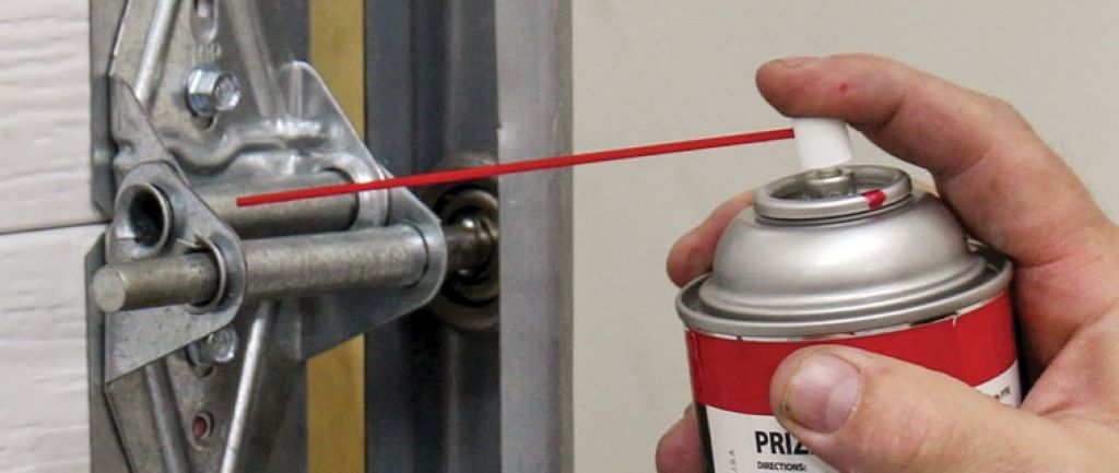 Step-by-step garage door hinge lubrication process showing proper application technique and safety equipment